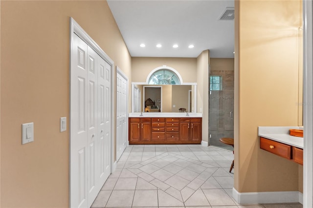 bathroom featuring tile patterned flooring, a shower with shower door, and vanity