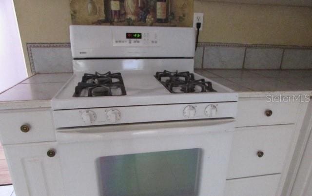 kitchen with white cabinetry and gas range gas stove