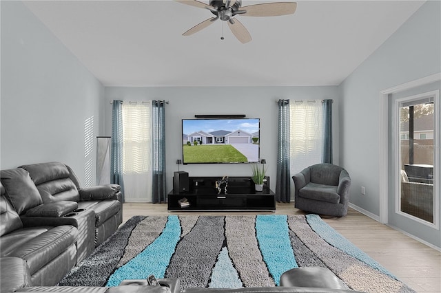 living room with ceiling fan, a healthy amount of sunlight, lofted ceiling, and light hardwood / wood-style flooring