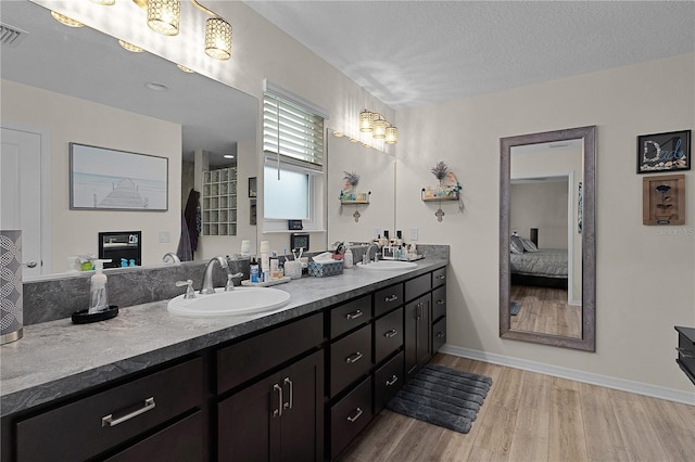 bathroom featuring vanity, a textured ceiling, and hardwood / wood-style flooring