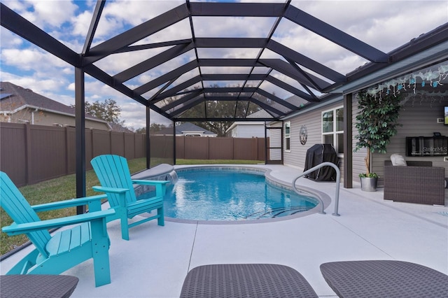 view of pool with a lanai, pool water feature, a patio area, and grilling area