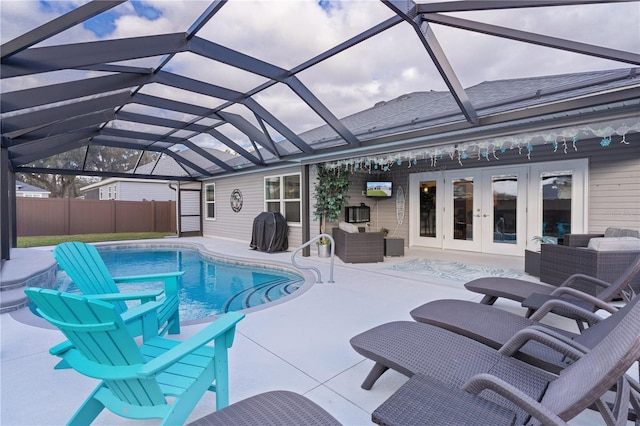 view of pool with a lanai, an outdoor living space, a patio area, and french doors