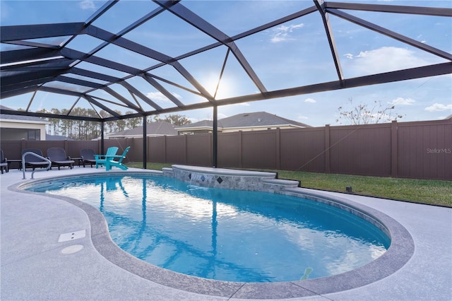 view of swimming pool featuring glass enclosure and a patio area