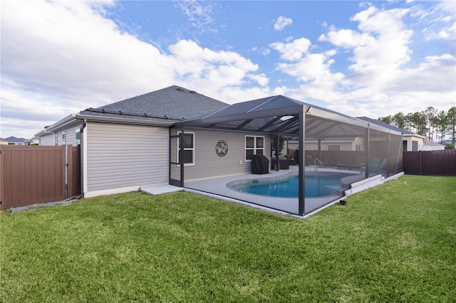 back of house with a lanai, a yard, and a fenced in pool