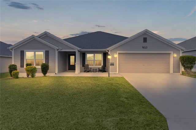 ranch-style home with a patio, a yard, and a garage