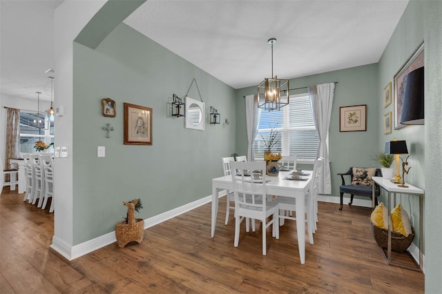 dining space with hardwood / wood-style floors and a chandelier