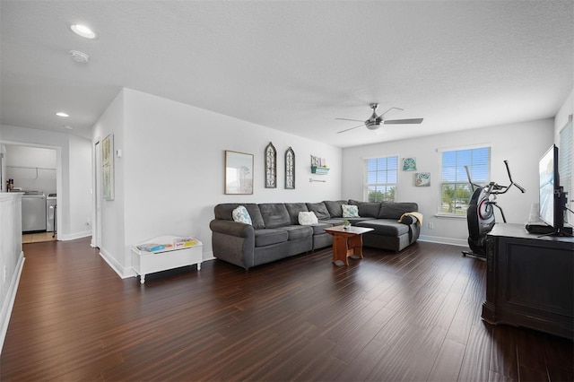 living room with washing machine and clothes dryer, ceiling fan, a textured ceiling, and dark hardwood / wood-style floors