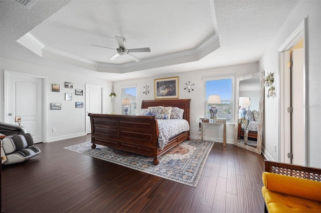 bedroom featuring ceiling fan, dark hardwood / wood-style floors, a raised ceiling, and a textured ceiling