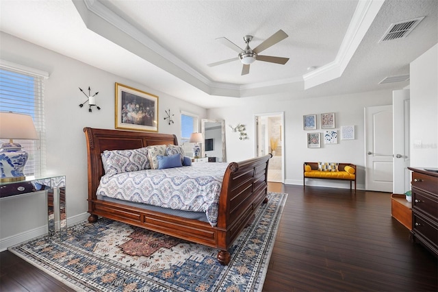 bedroom with a raised ceiling, crown molding, ceiling fan, dark hardwood / wood-style floors, and a textured ceiling