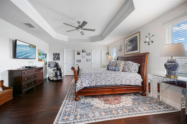 bedroom with a raised ceiling, ceiling fan, crown molding, and dark hardwood / wood-style floors