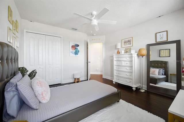 bedroom featuring ceiling fan, dark wood-type flooring, a closet, and a textured ceiling