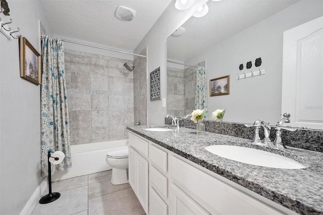 full bathroom with tile patterned flooring, toilet, vanity, shower / bath combo with shower curtain, and a textured ceiling