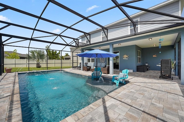 view of pool with a patio, pool water feature, and glass enclosure