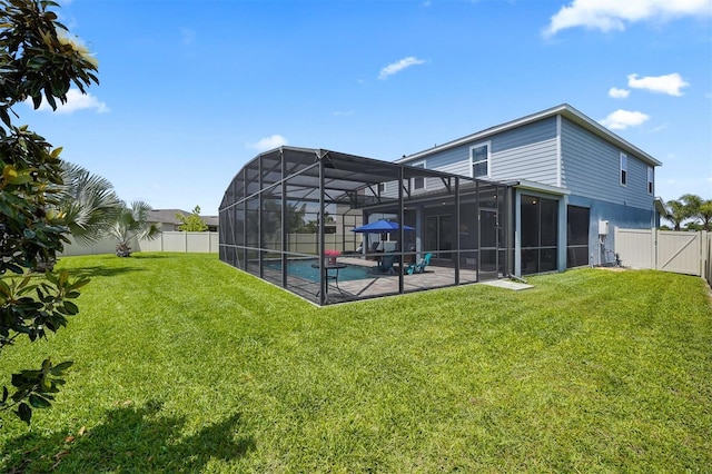 back of property with a fenced in pool, a yard, glass enclosure, and a patio area