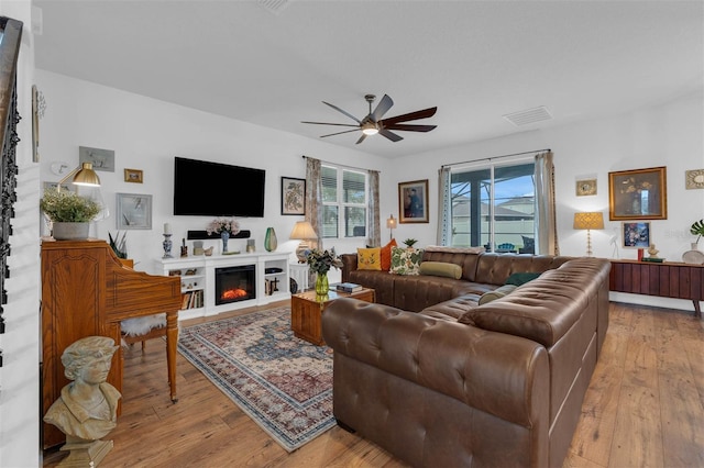 living room with light hardwood / wood-style floors and ceiling fan