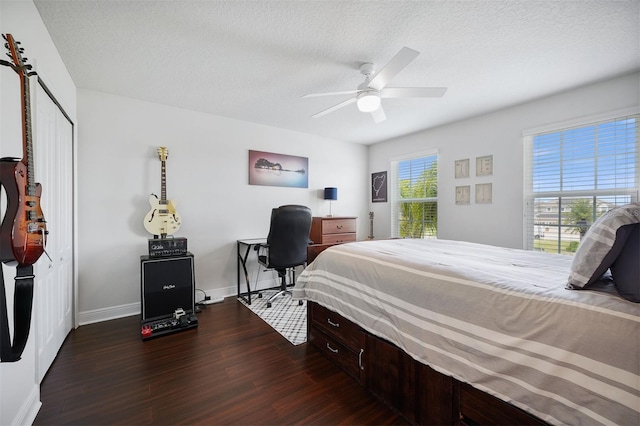 bedroom with dark wood-type flooring, a textured ceiling, and ceiling fan