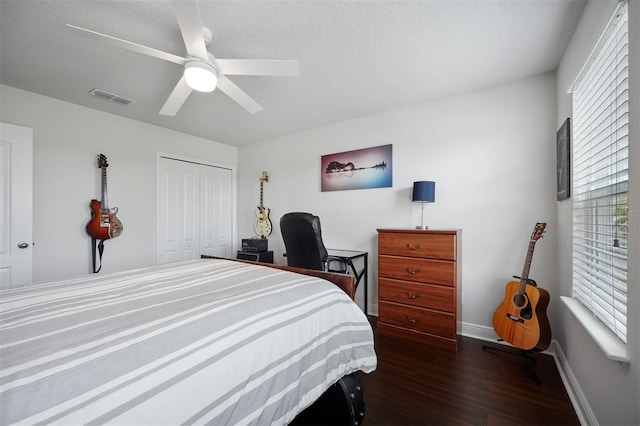 bedroom featuring a closet, ceiling fan, a textured ceiling, and dark hardwood / wood-style floors