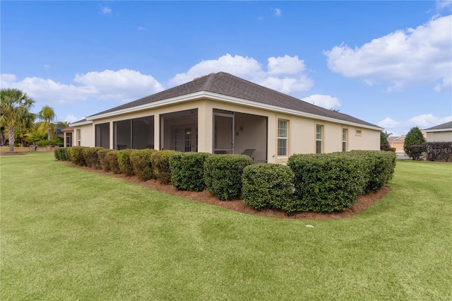 view of side of property featuring a sunroom and a lawn