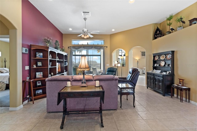 living room with ceiling fan, light tile patterned floors, and a towering ceiling