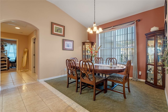 tiled dining area with an inviting chandelier and lofted ceiling