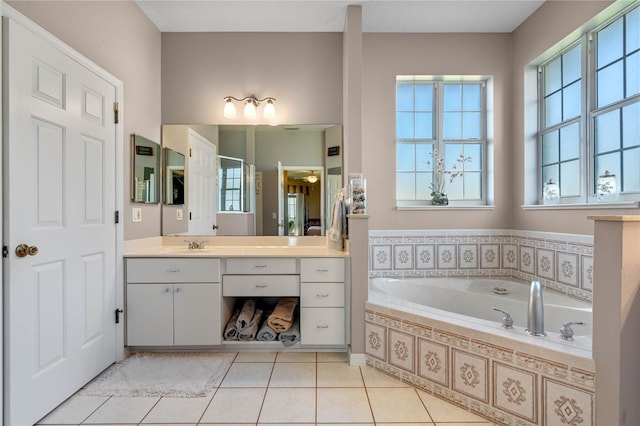 bathroom with tiled tub, tile patterned flooring, and vanity