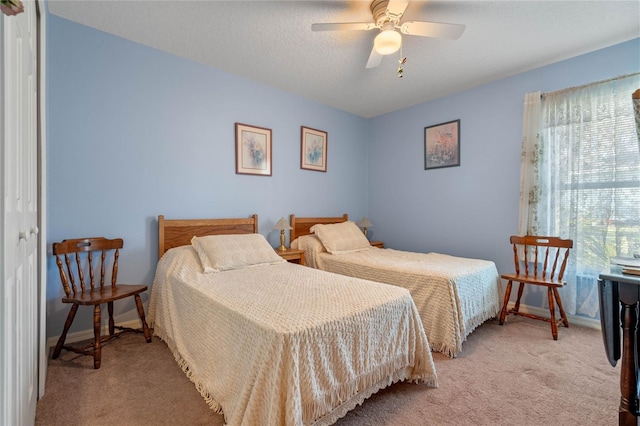 carpeted bedroom featuring ceiling fan, a textured ceiling, and a closet