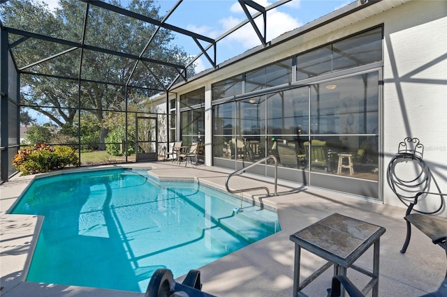 view of pool with glass enclosure and a patio