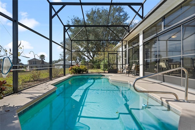 view of pool with a patio and glass enclosure