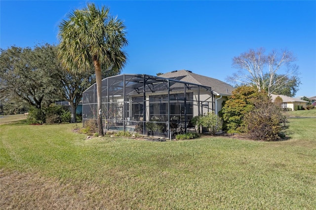 back of house featuring a lanai and a yard