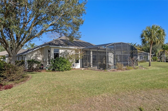 back of property featuring a lanai and a yard