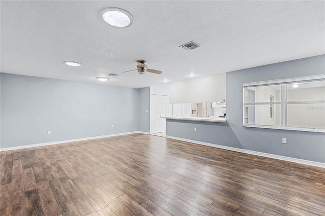 unfurnished living room with a textured ceiling, hardwood / wood-style flooring, and ceiling fan