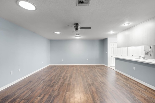 interior space with hardwood / wood-style floors, a textured ceiling, ceiling fan, and sink