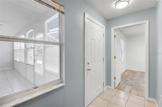 hall with light tile patterned floors