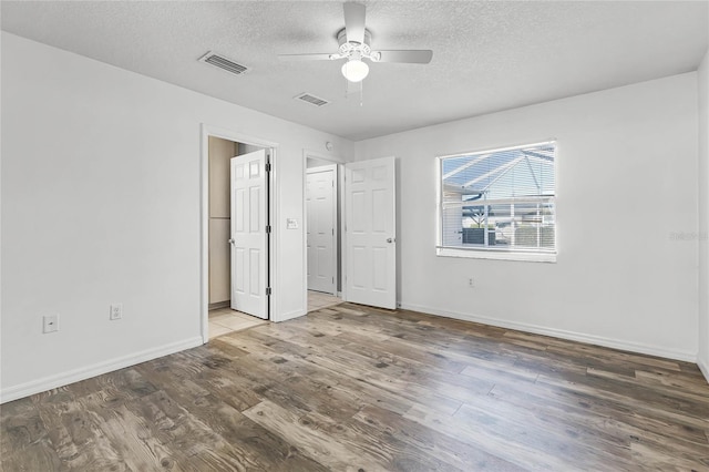 unfurnished bedroom with ceiling fan, wood-type flooring, and a textured ceiling