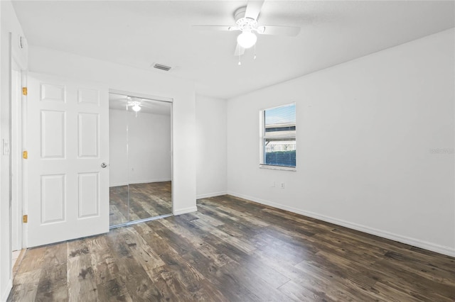 unfurnished bedroom featuring ceiling fan, dark hardwood / wood-style floors, and a closet