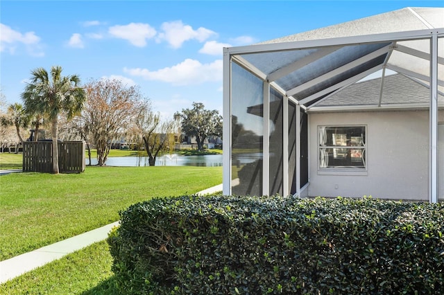 view of yard with a water view and glass enclosure