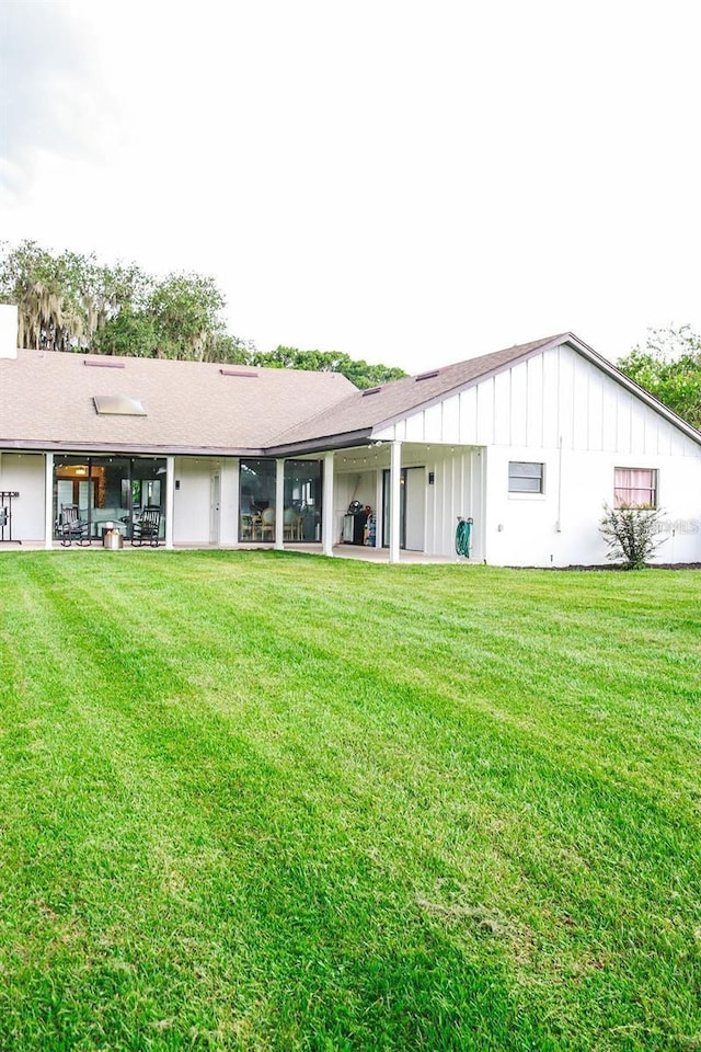 rear view of property featuring a lawn