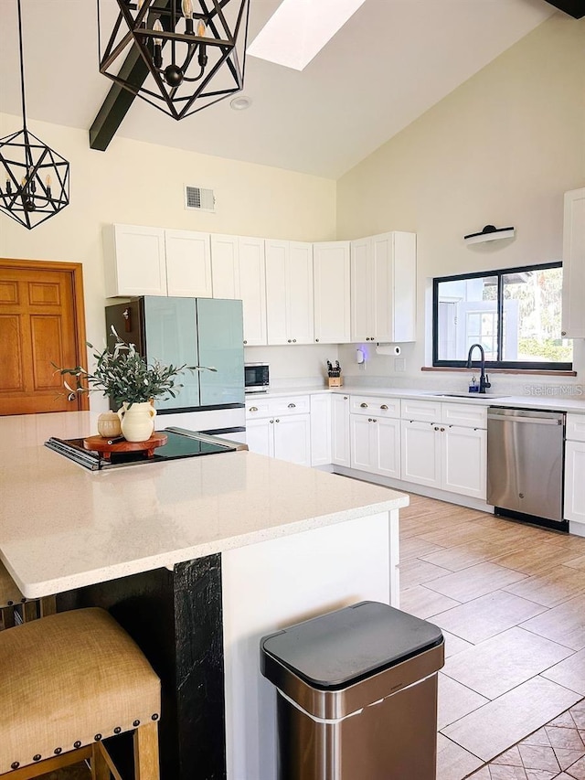 kitchen with a kitchen bar, white cabinets, pendant lighting, and appliances with stainless steel finishes