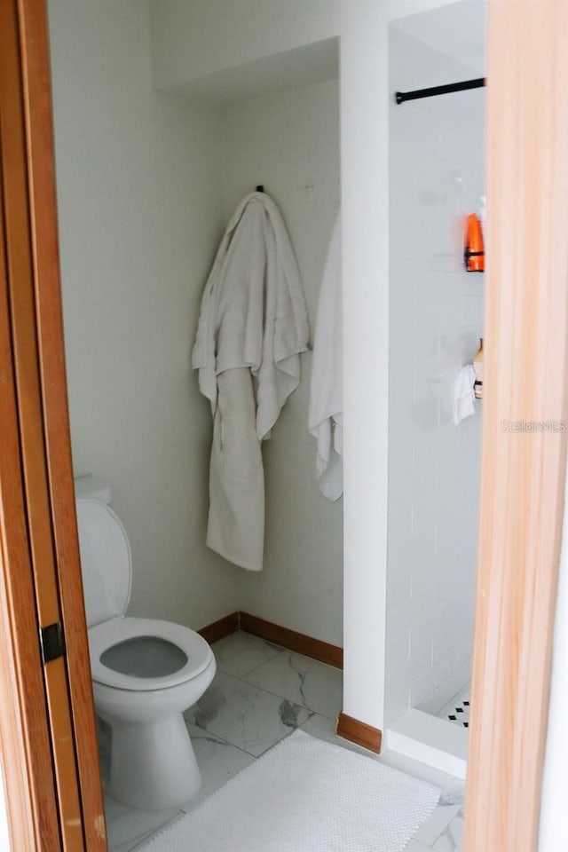 bathroom featuring walk in shower and toilet