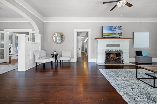 living room featuring a fireplace, dark hardwood / wood-style flooring, and ceiling fan