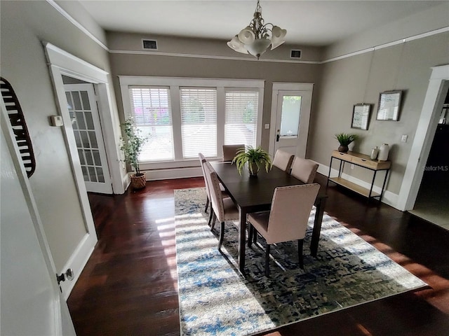 dining area featuring dark hardwood / wood-style floors and an inviting chandelier