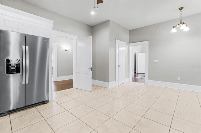 kitchen with ceiling fan with notable chandelier, white cabinetry, stainless steel fridge with ice dispenser, and light tile patterned floors