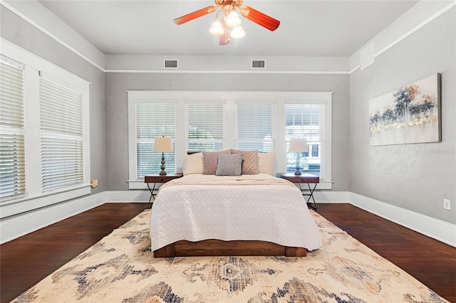 bedroom with dark hardwood / wood-style flooring and ceiling fan