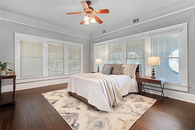 bedroom featuring ceiling fan, dark hardwood / wood-style flooring, and multiple windows