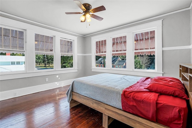 bedroom with ornamental molding, ceiling fan, and dark wood-type flooring