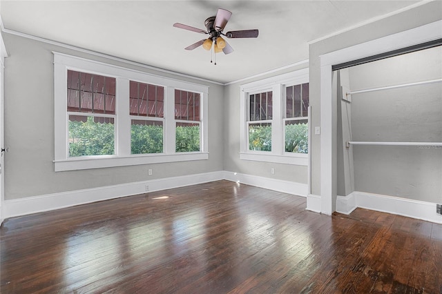 empty room featuring ceiling fan, dark hardwood / wood-style flooring, and ornamental molding