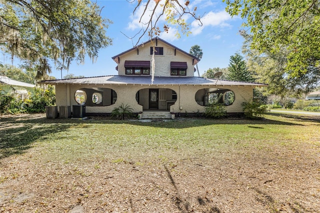 view of front of house with central AC and a front lawn