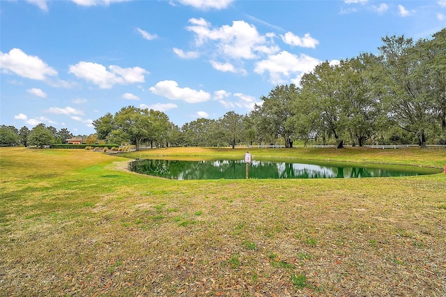 view of property's community with a lawn and a water view