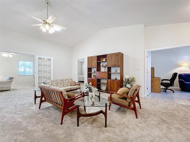 living room with a textured ceiling, ceiling fan, light carpet, and vaulted ceiling