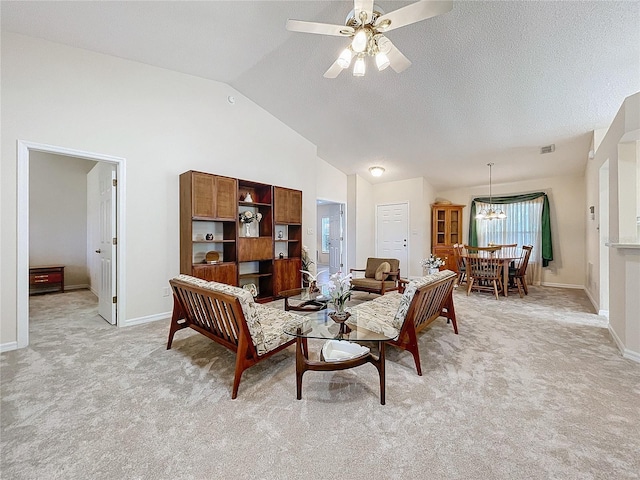 living room with ceiling fan with notable chandelier, light colored carpet, and lofted ceiling